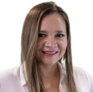 A woman with long, straight brown hair and a warm smile is wearing a white blouse. She has a light complexion and is positioned against a plain white background